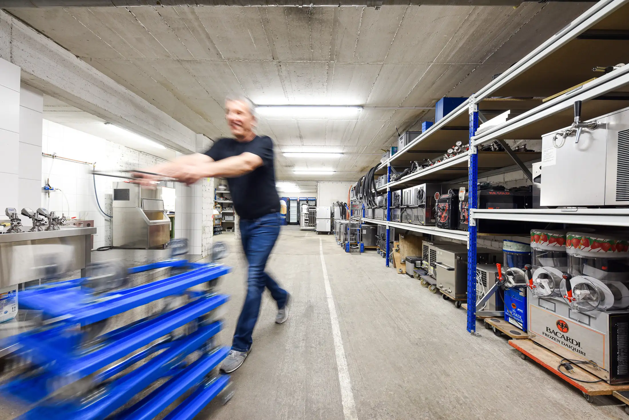 Mitarbeiter im Technik-Lager mit Kühlgeräten und Zapfanlagen